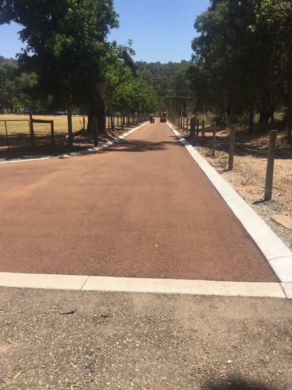 This is a photo of a hot spray & seal bitumen roadway which is in the process of being installed by Wagga Wagga Surfacing Solutions